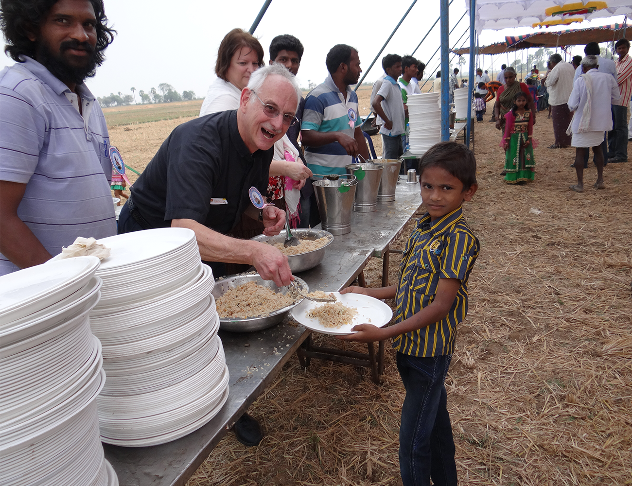 Father Dominic feeding hungry child