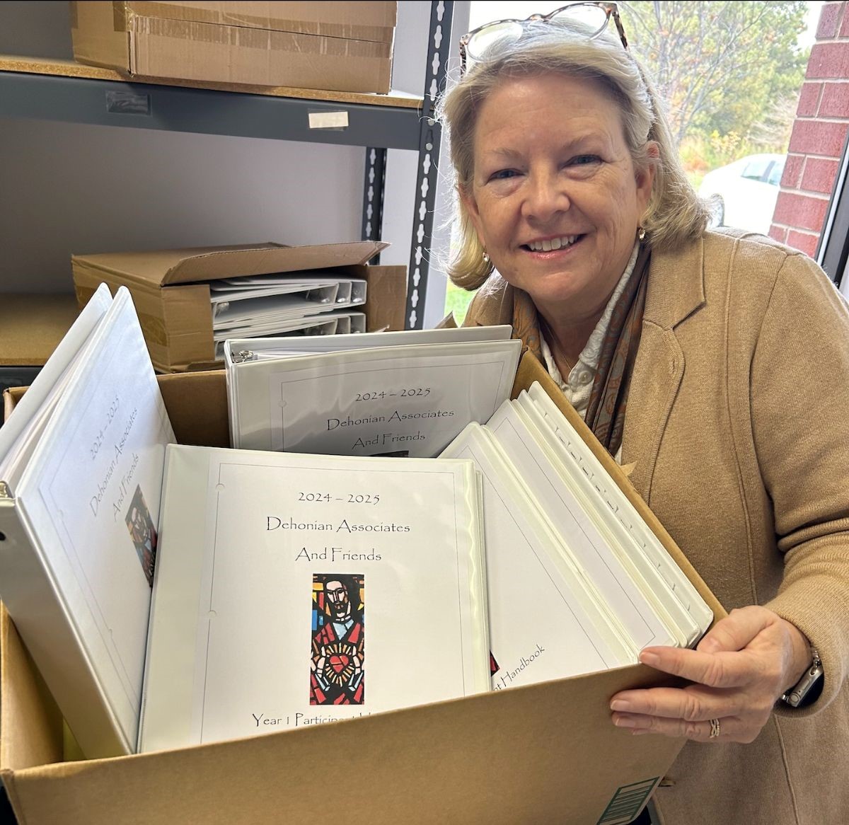 Pictured here is Monica Misey, Director of Dehonian Associates, packing up a box of handbooks for the Dehonian Associates participants in Houston.